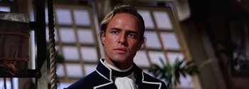 Movie still from “Mutiny on the Bounty” (1962), directed by George Seaton – A person wearing a suit and tie; Close Up shot, Low angle