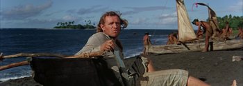 Movie still from “Mutiny on the Bounty” (1962), directed by George Seaton – A man standing next to a body of water; Medium shot, Low angle