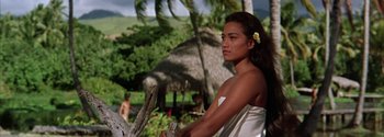 Movie still from “Mutiny on the Bounty” (1962), directed by George Seaton – A beautiful young woman with a flower in her hair; Medium shot, Over the shoulder angle