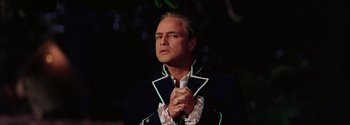 Movie still from “Mutiny on the Bounty” (1962), directed by George Seaton – A man in a suit is holding his hands in prayer; Close Up shot, Low angle