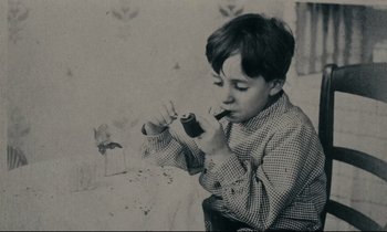 Movie still from “My American Uncle” (1980), directed by Alain Resnais – A young boy is holding something in his mouth; Medium shot, High angle