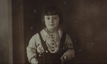 Movie still from “My American Uncle” (1980), directed by Alain Resnais – An old photo of a young boy wearing a bib; Close Up shot, High angle