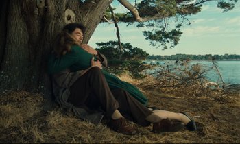 Movie still from “My American Uncle” (1980), directed by Alain Resnais – A woman leaning against a tree hugging a man; Wide shot, High angle