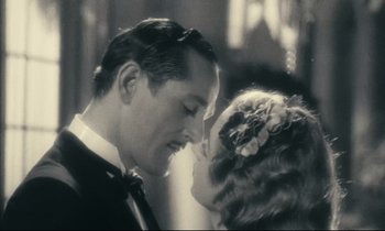 Movie still from “My American Uncle” (1980), directed by Alain Resnais – A man and a woman kissing each other in front of each other; Close Up shot, High angle