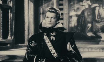 Movie still from “My American Uncle” (1980), directed by Alain Resnais – A black and white photo of a man in a suit; Medium shot, Over the shoulder angle