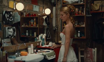 Movie still from “My American Uncle” (1980), directed by Alain Resnais – A woman standing in front of a mirror in a room; Medium shot, High angle