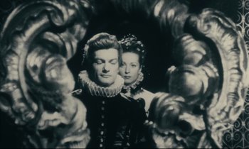 Movie still from “My American Uncle” (1980), directed by Alain Resnais – A man and a woman standing next to each other; Medium shot, Low angle