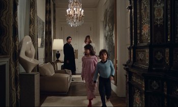 Movie still from “My American Uncle” (1980), directed by Alain Resnais – Two children and an adult are walking in a hallway; Wide shot, Low angle