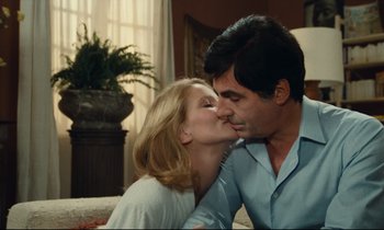 Movie still from “My American Uncle” (1980), directed by Alain Resnais – A man and a woman kissing in a living room; Close Up shot, Over the shoulder angle