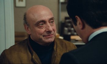 Movie still from “My American Uncle” (1980), directed by Alain Resnais – An older man with a bald head talking to a younger man; Close Up shot, Over the shoulder angle
