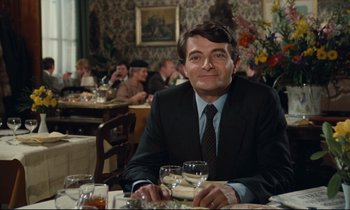 Movie still from “My American Uncle” (1980), directed by Alain Resnais – A man sitting at a table in a restaurant; Medium shot, Over the shoulder angle