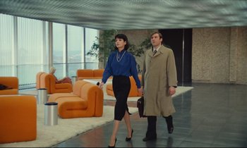 Movie still from “My American Uncle” (1980), directed by Alain Resnais – A man and a woman are walking in a lobby; Wide shot, Low angle