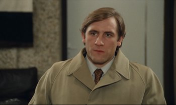 Movie still from “My American Uncle” (1980), directed by Alain Resnais – A person wearing a coat and tie; Close Up shot, Over the shoulder angle