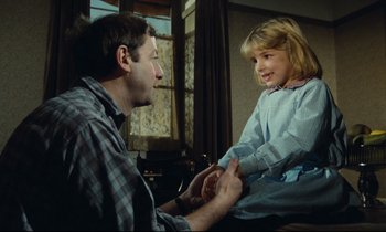Movie still from “My American Uncle” (1980), directed by Alain Resnais – A man and a little girl sitting in a room; Medium shot, Over the shoulder angle
