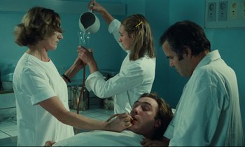 Movie still from “My American Uncle” (1980), directed by Alain Resnais – A group of people in white lab coats in a room; Medium shot, Low angle
