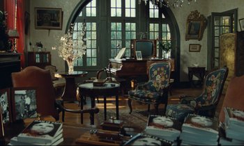 Movie still from “My American Uncle” (1980), directed by Alain Resnais – A living room filled with lots of furniture and a large window; Wide shot, High angle