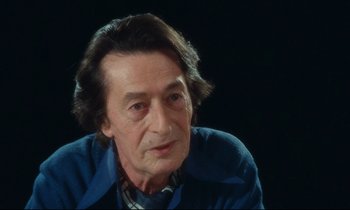 Movie still from “My American Uncle” (1980), directed by Alain Resnais – A person sitting in a room; Close Up shot, High angle