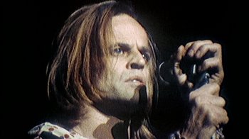 Movie still from “My Best Fiend” (1999), directed by Werner Herzog – A person with long hair holding a camera; Close Up shot, Low angle