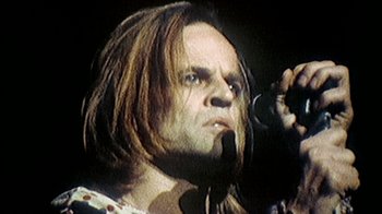 Movie still from “My Best Fiend” (1999), directed by Werner Herzog – A person with long hair holding a microphone; Close Up shot, Low angle