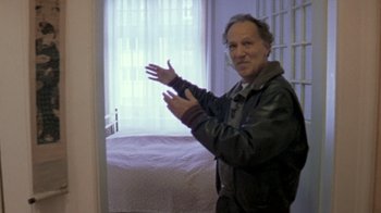 Movie still from “My Best Fiend” (1999), directed by Werner Herzog – A man standing in front of a bed in front of a window; Medium shot, Low angle