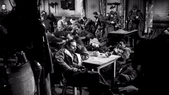 Movie still from “My Best Fiend” (1999), directed by Werner Herzog – A group of men sitting around a table; Wide shot, High angle