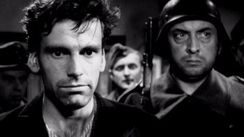 Movie still from “My Best Fiend” (1999), directed by Werner Herzog – A black and white photo of a man and two other men; Close Up shot, Over the shoulder angle