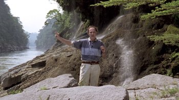 Movie still from “My Best Fiend” (1999), directed by Werner Herzog – A man standing in front of a waterfall pointing; Wide shot, Low angle