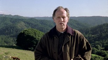 Movie still from “My Best Fiend” (1999), directed by Werner Herzog – An older man standing in front of a mountain range; Close Up shot, Low angle