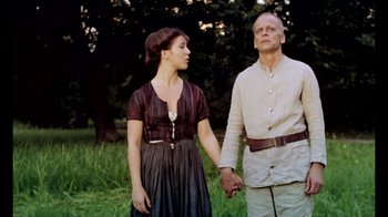 Movie still from “My Best Fiend” (1999), directed by Werner Herzog – A man and a woman holding hands while standing next to each other; Medium shot, Low angle