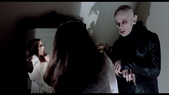 Movie still from “My Best Fiend” (1999), directed by Werner Herzog – Two women and a man in a dark room; Medium shot, Over the shoulder angle