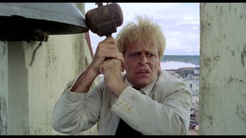 Movie still from “My Best Fiend” (1999), directed by Werner Herzog – A man holding a hammer up to his head; Close Up shot, Low angle