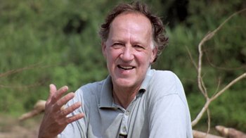 Movie still from “My Best Fiend” (1999), directed by Werner Herzog – An older man smiling and holding his hand out; Close Up shot, Low angle