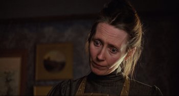 Movie still from “My Brilliant Career” (1979), directed by Gillian Armstrong – A woman in a brown apron looking at the camera; Close Up shot, Low angle