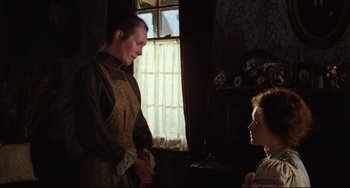 Movie still from “My Brilliant Career” (1979), directed by Gillian Armstrong – A man and a woman standing next to each other in front of a window; Medium shot, Over the shoulder angle