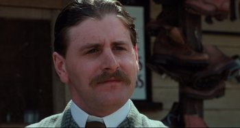 Movie still from “My Brilliant Career” (1979), directed by Gillian Armstrong – A person wearing a suit and a tie; Close Up shot, Low angle