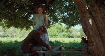 Movie still from “My Brilliant Career” (1979), directed by Gillian Armstrong – A man and a woman standing next to a tree; Wide shot, Low angle