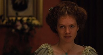 Movie still from “My Brilliant Career” (1979), directed by Gillian Armstrong – A woman with curly brown hair wearing a green necklace; Close Up shot, Over the shoulder angle