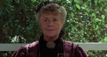 Movie still from “My Brilliant Career” (1979), directed by Gillian Armstrong – An older woman wearing a purple dress and a black hat; Close Up shot, Low angle