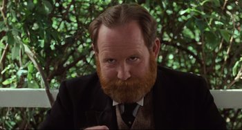 Movie still from “My Brilliant Career” (1979), directed by Gillian Armstrong – A man with a beard wearing a suit and tie; Close Up shot, Over the shoulder angle