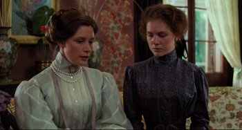 Movie still from “My Brilliant Career” (1979), directed by Gillian Armstrong – Two women are standing next to each other in a room; Medium shot, Low angle