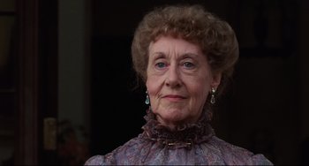 Movie still from “My Brilliant Career” (1979), directed by Gillian Armstrong – An older woman wearing a dress and a necklace; Close Up shot, Low angle