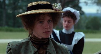 Movie still from “My Brilliant Career” (1979), directed by Gillian Armstrong – A woman wearing a straw hat with a cat on it; Close Up shot, Over the shoulder angle