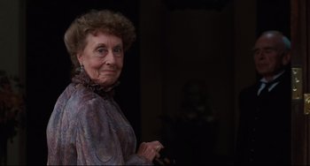 Movie still from “My Brilliant Career” (1979), directed by Gillian Armstrong – An older woman is smiling for the camera; Close Up shot, Over the shoulder angle