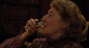Movie still from “My Brilliant Career” (1979), directed by Gillian Armstrong – An older woman drinking a glass of red wine; Close Up shot, High angle