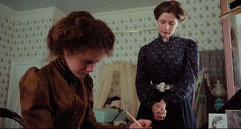 Movie still from “My Brilliant Career” (1979), directed by Gillian Armstrong – Two women are writing on a piece of paper in a room; Medium shot, Low angle