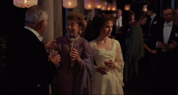 Movie still from “My Brilliant Career” (1979), directed by Gillian Armstrong – Two women and an older man are standing together; Medium shot, Over the shoulder angle