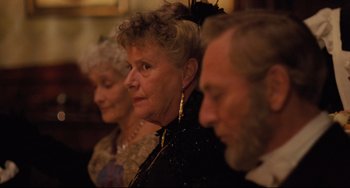 Movie still from “My Brilliant Career” (1979), directed by Gillian Armstrong – A group of older people sitting next to each other; Close Up shot, Over the shoulder angle