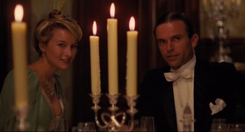 Movie still from “My Brilliant Career” (1979), directed by Gillian Armstrong – A man and a woman sitting in front of candles; Medium shot, Low angle