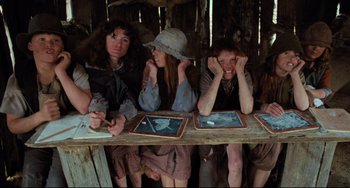 Movie still from “My Brilliant Career” (1979), directed by Gillian Armstrong – A group of people sitting at a wooden table; Medium shot, High angle