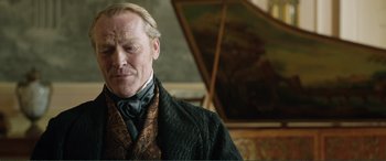 Movie still from “My Cousin Rachel” (2017), directed by Roger Michell – A man in a suit and tie standing in front of a painting; Close Up shot, Over the shoulder angle